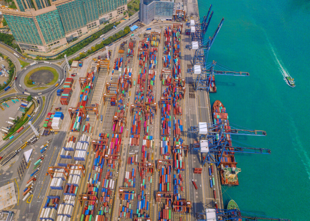 Aerial top view of container cargo ship in the export and import business and logistics international goods in urban city Shipping to the harbor by crane in Victoria Harbour Hong Kong