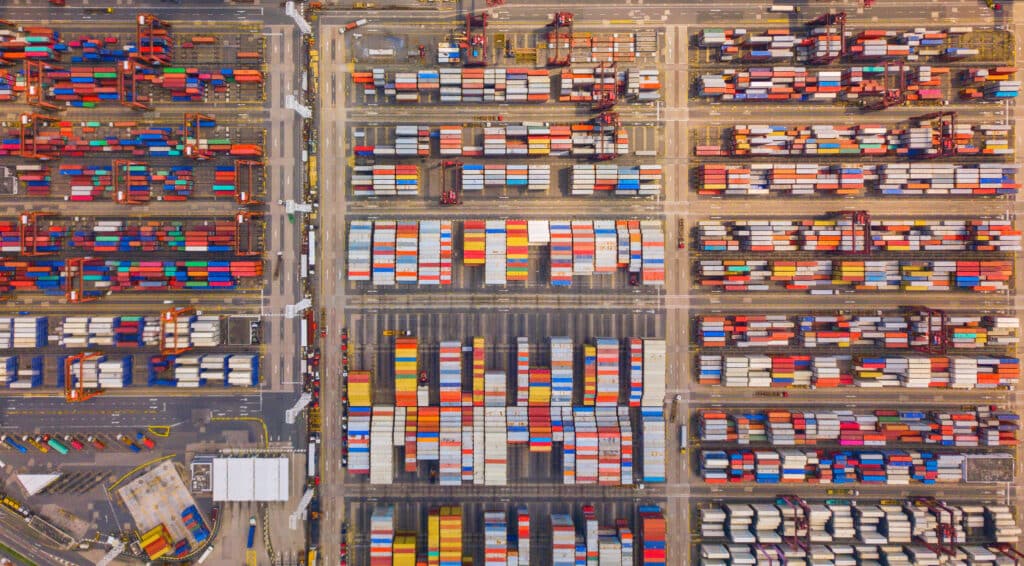 Aerial top view of container cargo ship in the export and import business and logistics international goods in urban city Shipping to the harbor by crane in Victoria Harbour Hong Kong